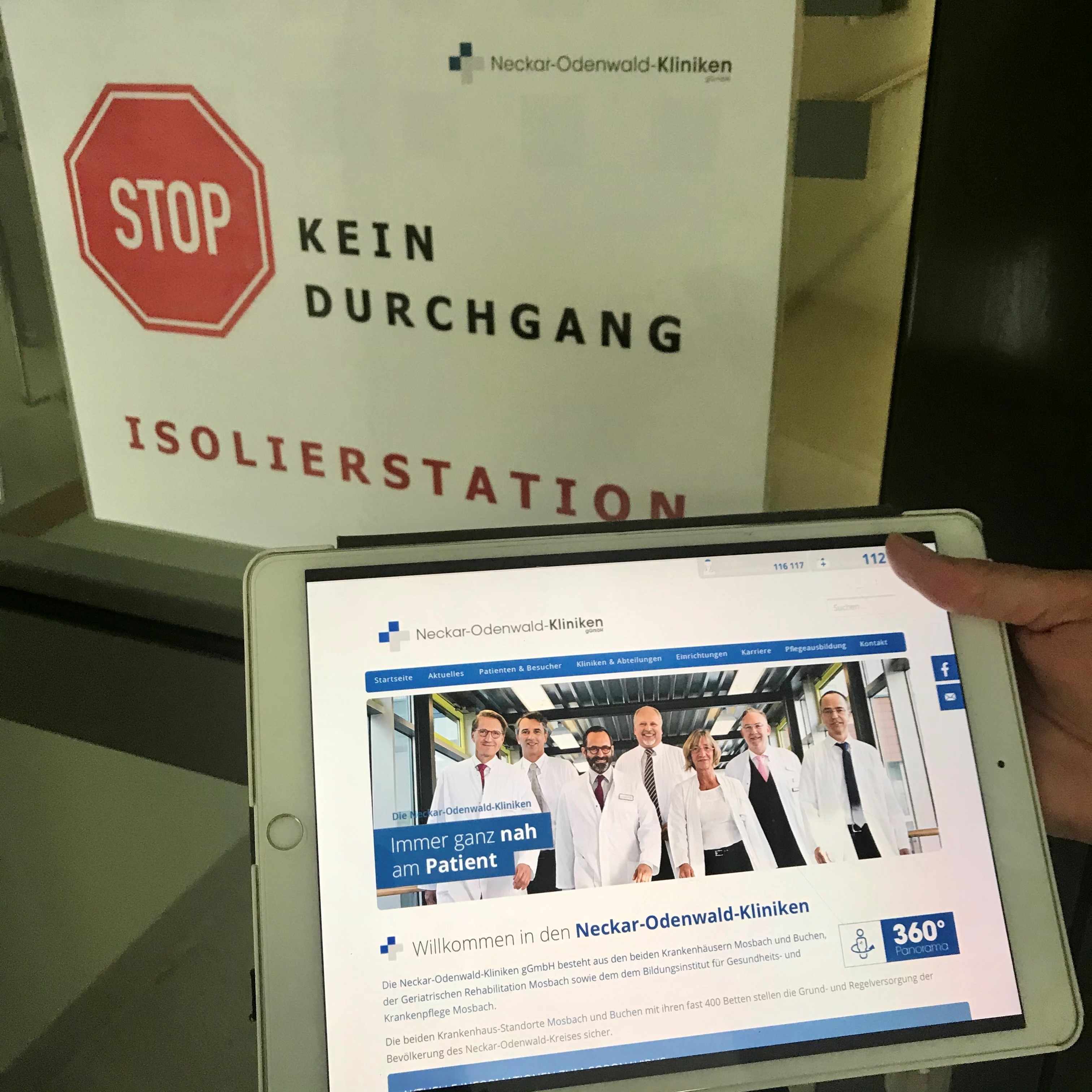 IPad mit Webseite der Neckar-Odenwald-Kliniken und einem Schild "Kein Durchgang Isolierstation"